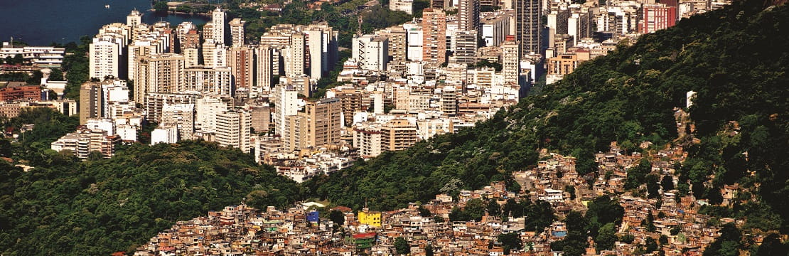 An elevated view of a city. The top portion is packed with skyscrapers, while the outskirts on the bottom appear less developed.
